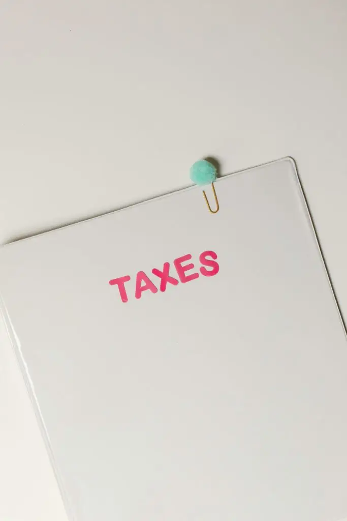 A black piece of paper with 'taxes' written across in pink.