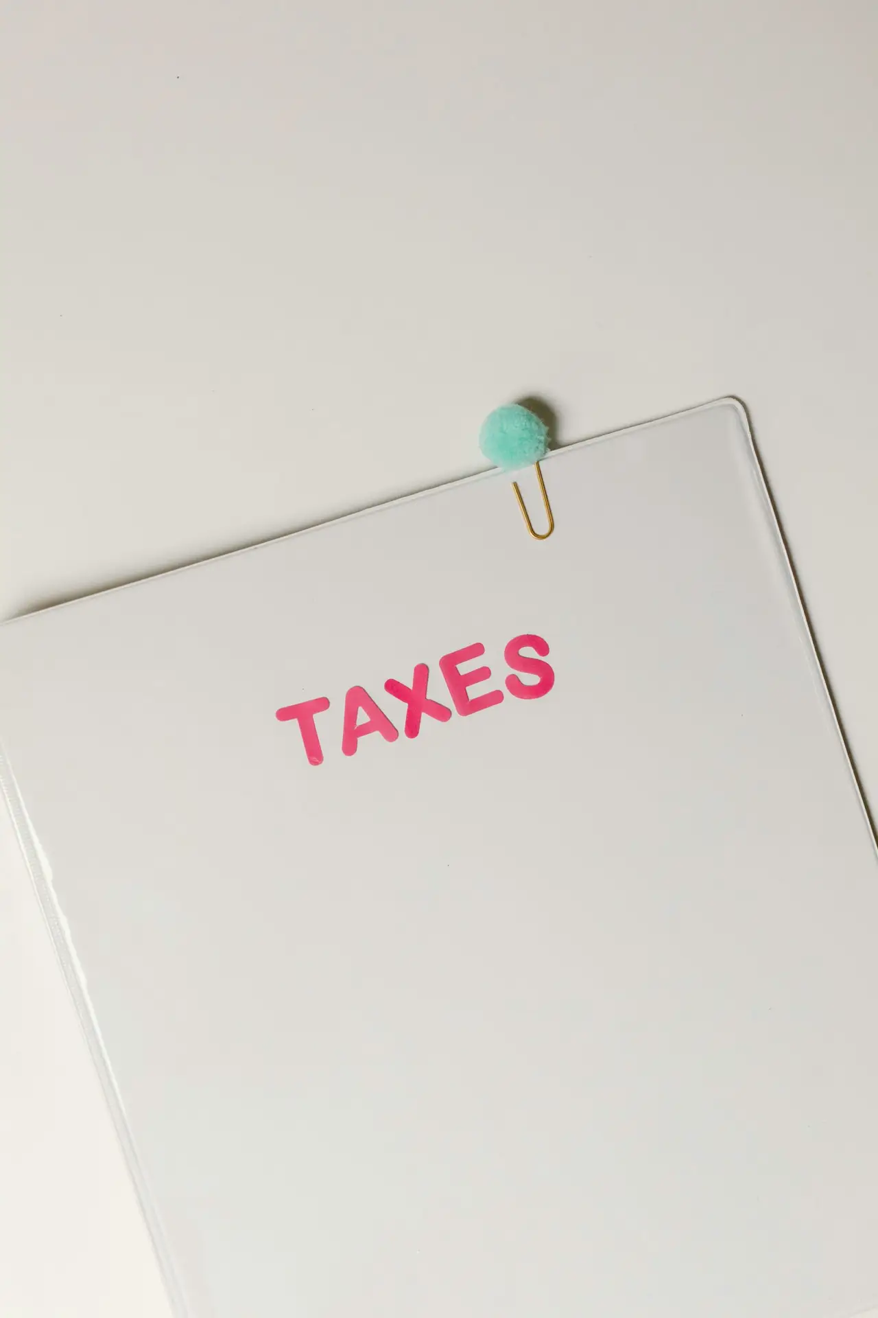 A black piece of paper with 'taxes' written across in pink.